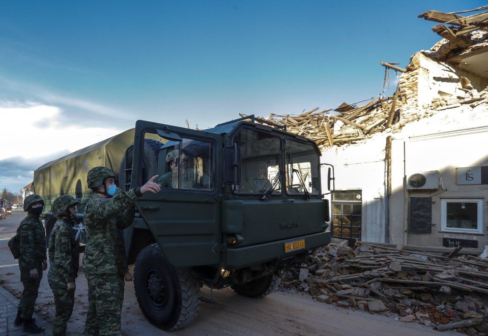 Soldiers speak with one another amid rescue operations