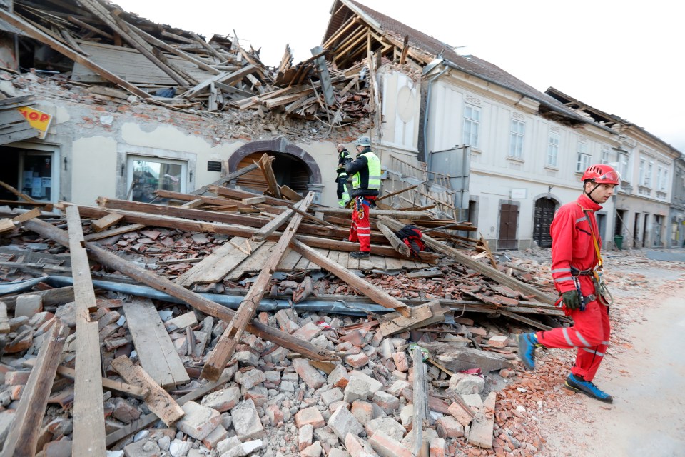 Emergency workers inspect a collapsed building