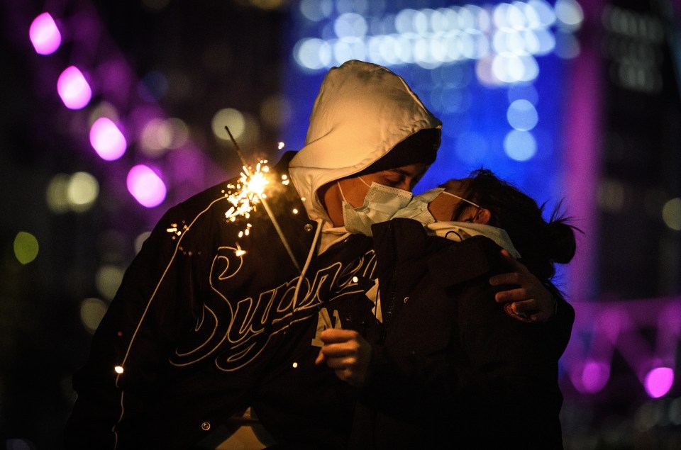 A couple pose for a picture in front of the London Eye