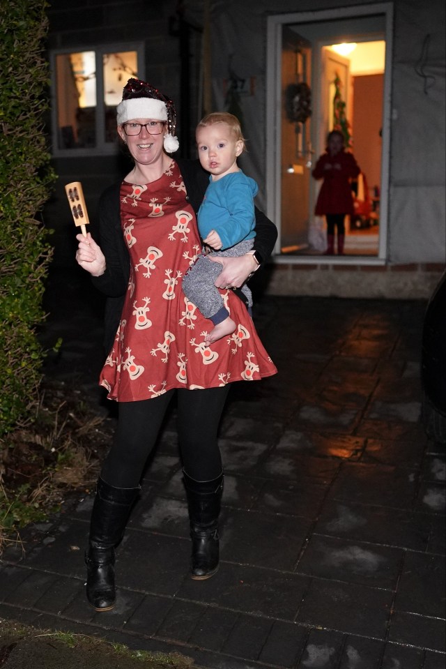 A resident in Saltburn, North Yorkshire steps out to spread festive cheer and ring a bell this evening