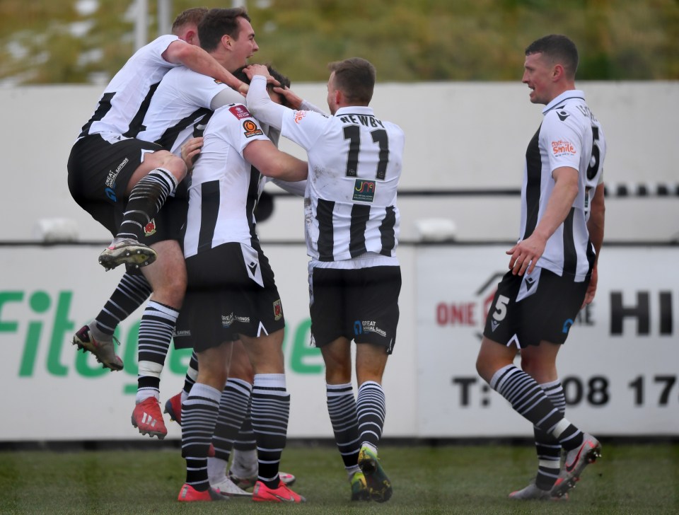 Chorley mob Mike Calveley after he poached their match-sealing second goal for the greatest result in the Non-Leaguers' history