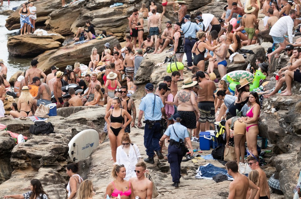 Police patrol the large crowds at Gordons Bay in Sydney earlier today