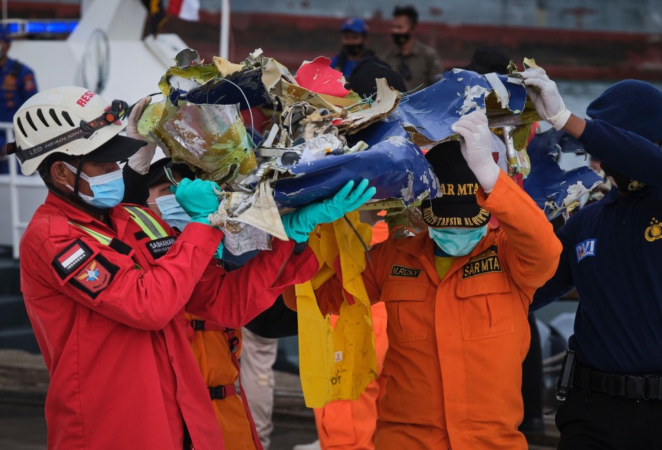 Rescuers bringing wreckage from the plane ashore 