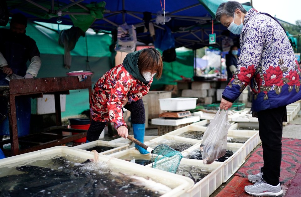 Vendors sell fish in an open market in Wuhan on December 2, a year after the virus began to take hold of the city