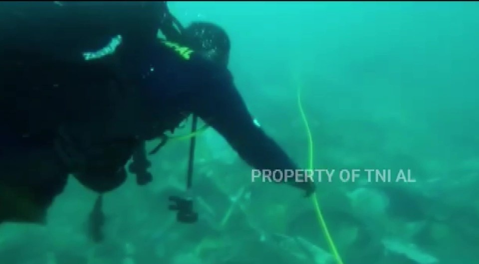 Divers from the Indonesian Navy are searching the underwater wreckage