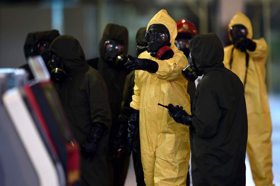 Malaysian authorities in hazmat suits decontaminating the airport after the attack 