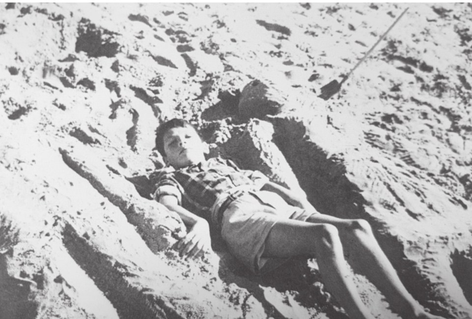 The monster, then aged 10, plays on the beach during a holiday