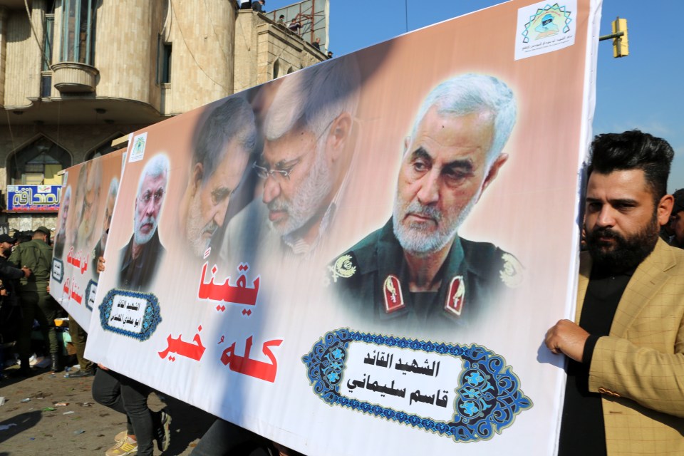 Supporters of Iran-backed Iraqi Shiite Popular Mobilization Forces hold the picture of Qasem Soleimani during a demonstration on the first anniversary of his death