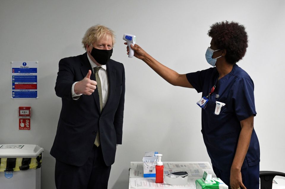 Prime Minister Boris Johnson has his temperature checked during a visit to Chase Farm Hospital in north London