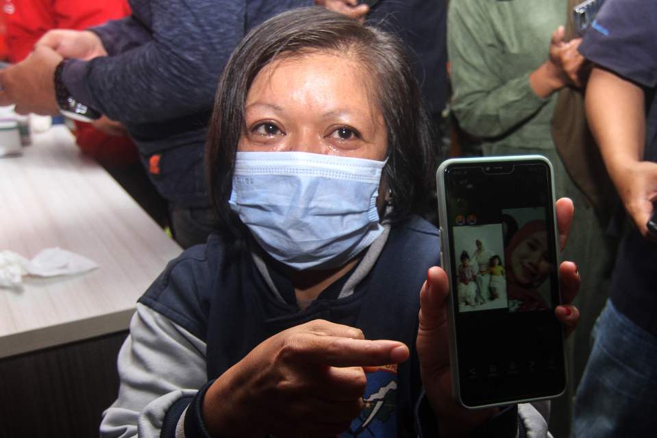 Lena shows a picture of her daughter, Dinda Amelia, who was on the flight