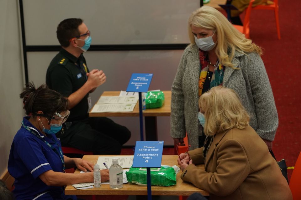 A woman talks to a healthcare worker before she receives an injection at the Centre for Life in Times Square, Newcastle