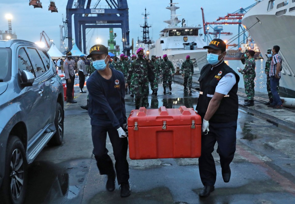 Crash investigators carry a box containing the flight data recorder from Sriwijaya Air flight 182