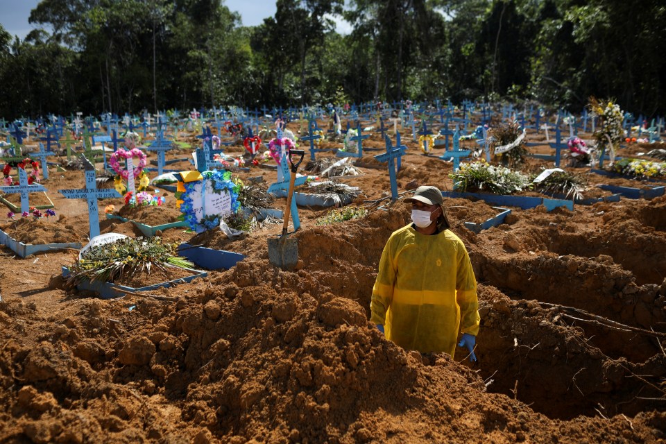 A gravedigger stands amongst a sea of crosses as Brazil has suffered the second highest Covid death toll in the world