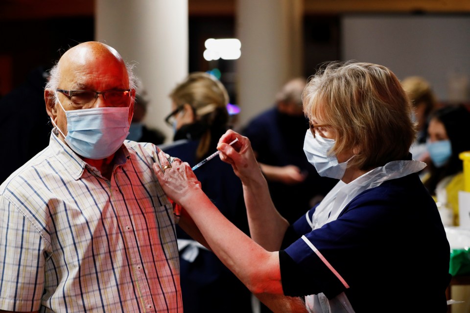 A man receives a Covid vaccine in Batchwood Hall, St Albans