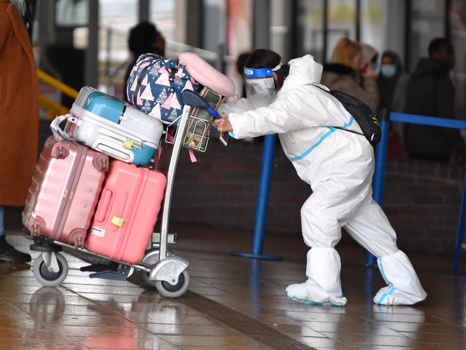 One woman in Manchester wore a hazmat suit as she struggled to push her heavy load of luggage 