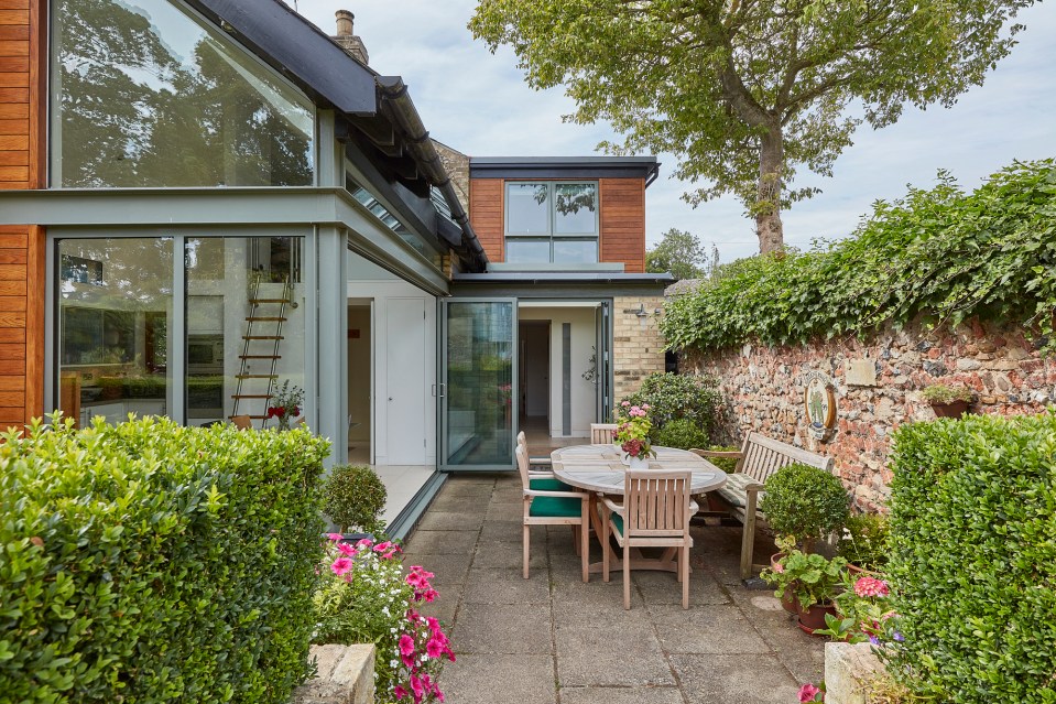 The large glass doors open onto a pretty courtyard area, surrounded by a stone wall