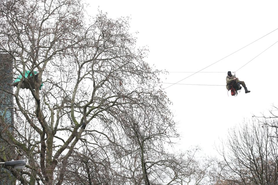 A man is seen on a zipwire above the camp