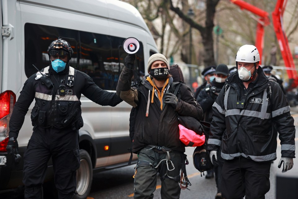 Another activist is led away by the eviction team