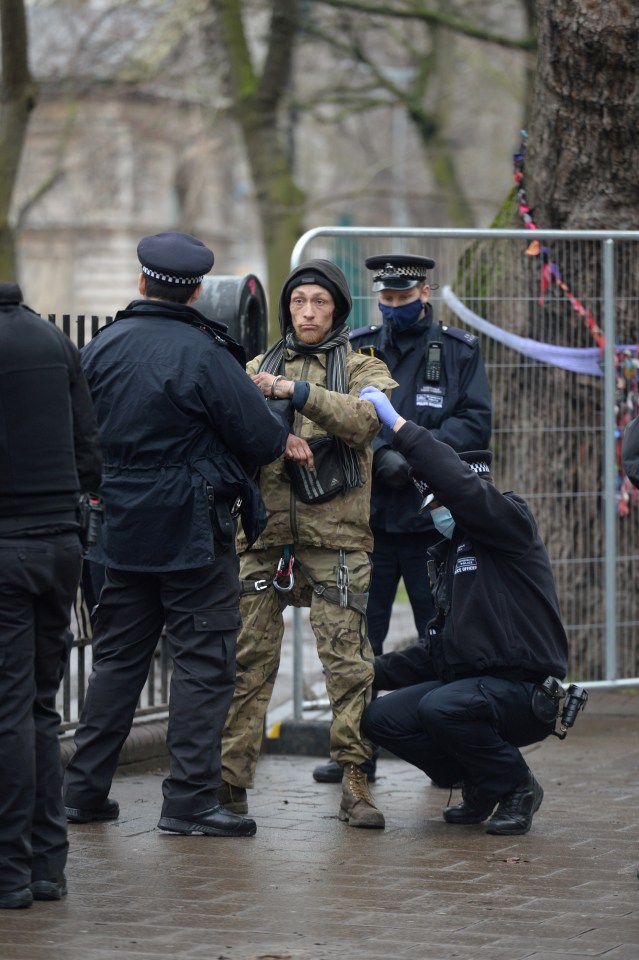 A man is searched by police at the campsite