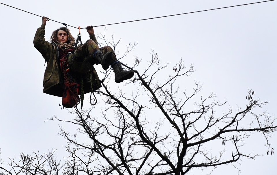 A protester makes their way along a zipline