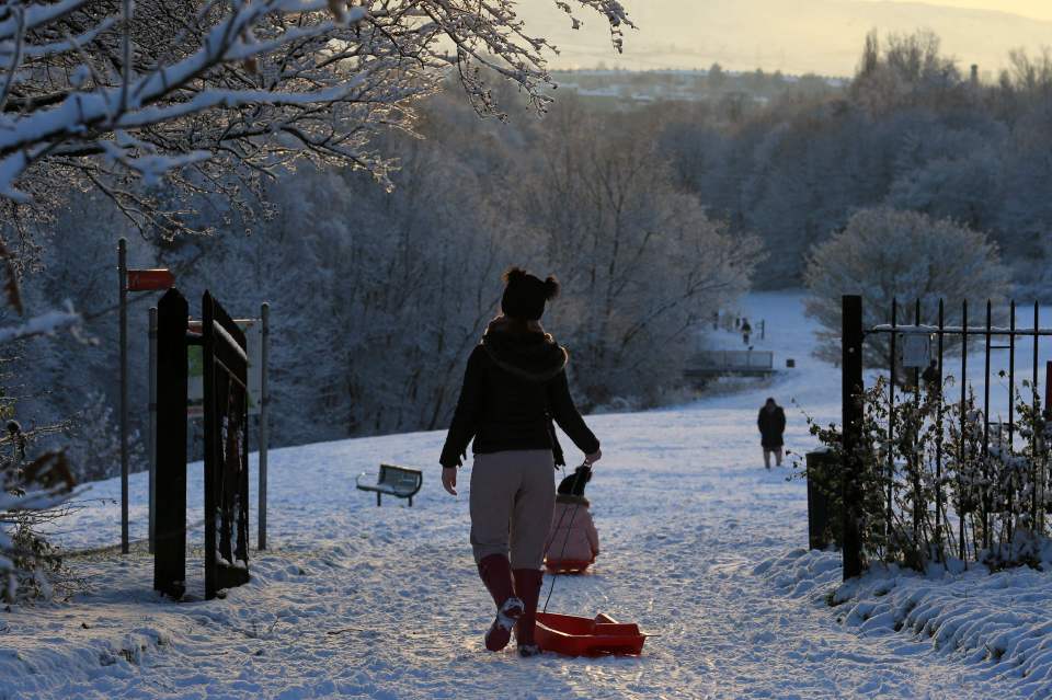 Sledgers enjoy the snowy conditions in Brun Valley Forest Park in Burnley, north-west England