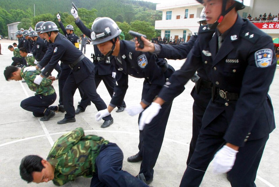 Police officers practice executing supposed prisoners with a shot to the head