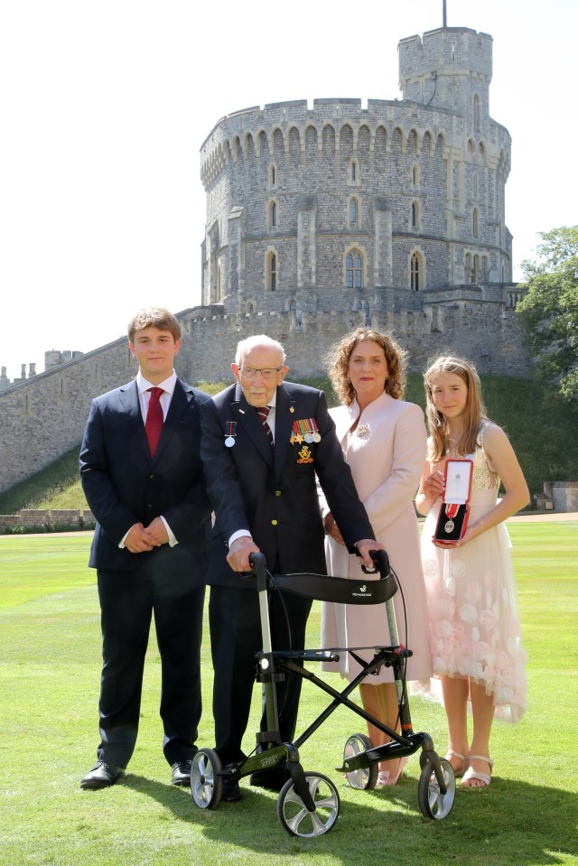 Captain Sir Thomas Moore poses with his family after being awarded with the insignia of Knight Bachelor by Queen Elizabeth II at Windsor Castle on July 17