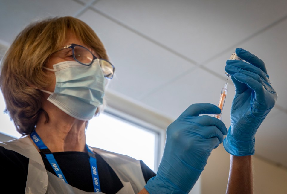 A medical professional prepares a vaccine amid the mass roll out