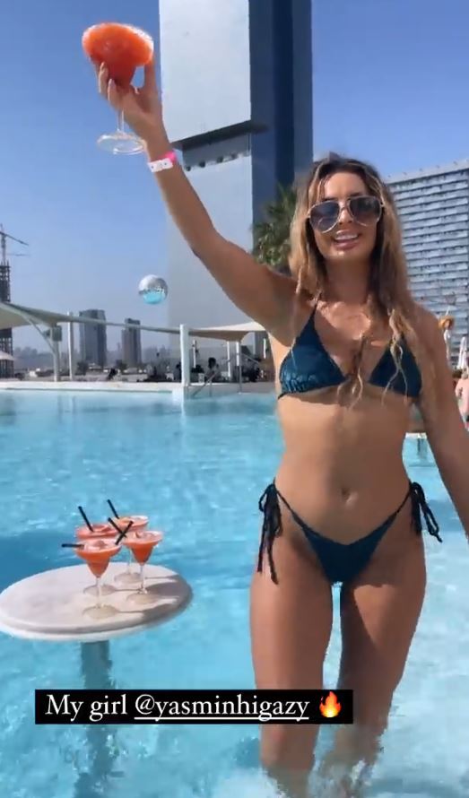 One influencer cheers with a cocktail while soaking up the sun in Dubai