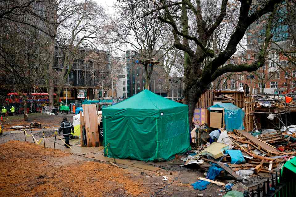 A green tent covers the entrance to a series of tunnels occupied by protesters