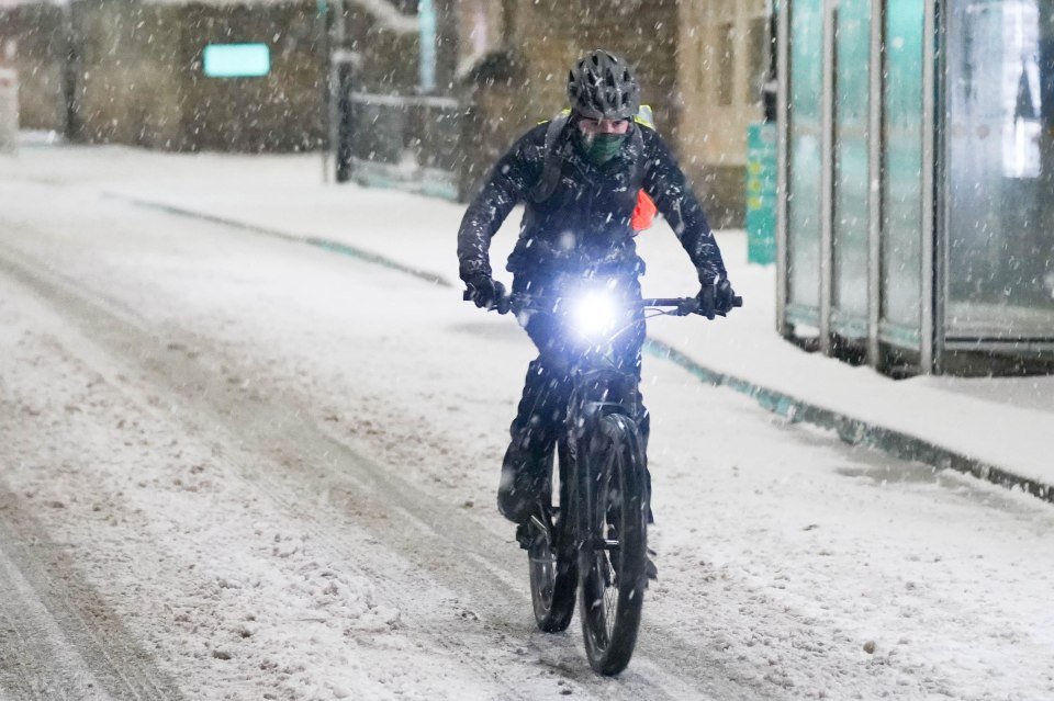 A cyclist struggles through a blizzard in Sheffield this morning