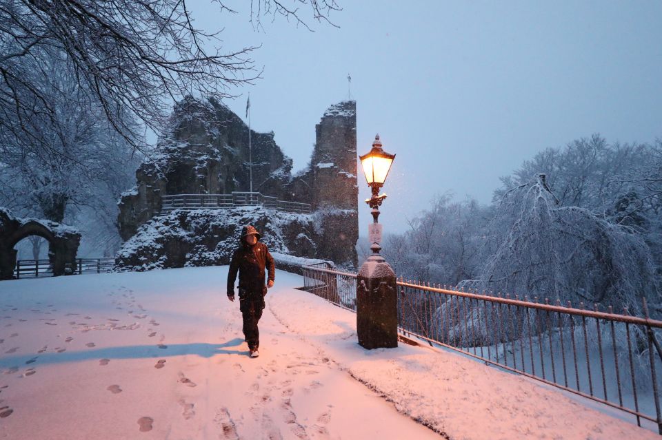 A man walks near the castle in Knaresborough, North Yorks after heavy snow fell overnight