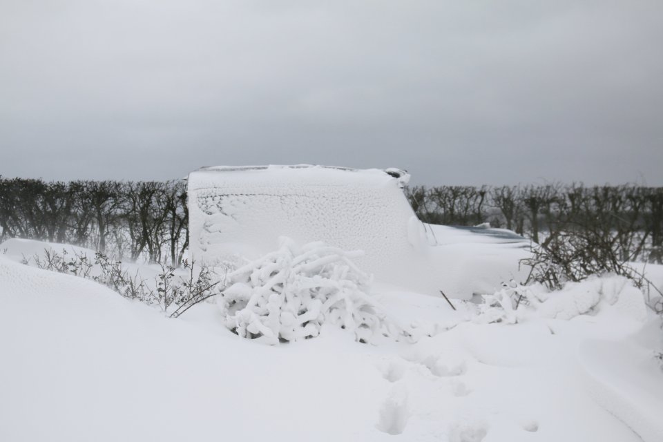 In Orford, Suffolk, two Land Rovers were abandoned overnight on a road after heavy snow blanketed both vehicles