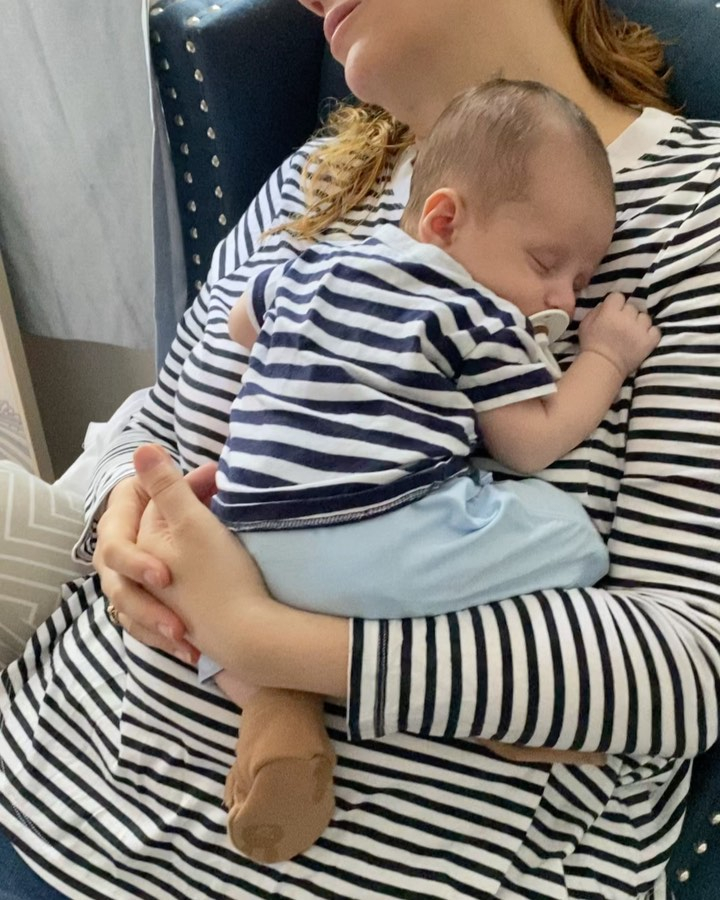 Jules holding Oliver in matching outifts at home