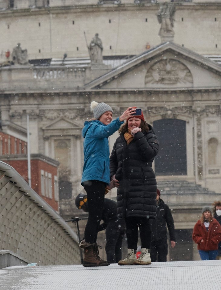 Friends snapped a selfie on London's Millennium Bridge as snow fell in London