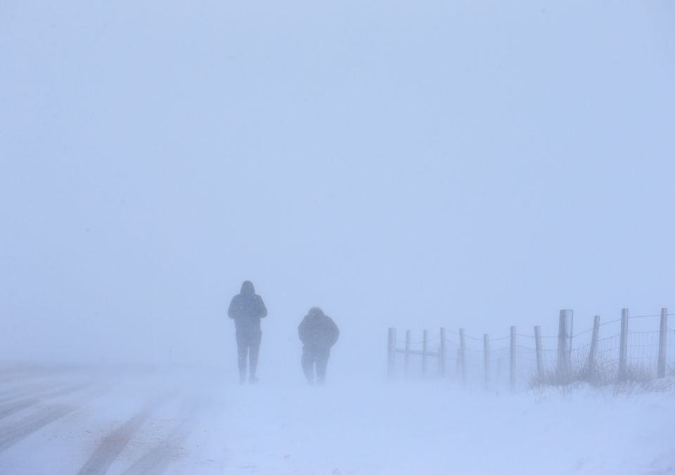 Walkers make their way through the snow during a blizzard-like conditions in Saddleworth, Greater Manchester