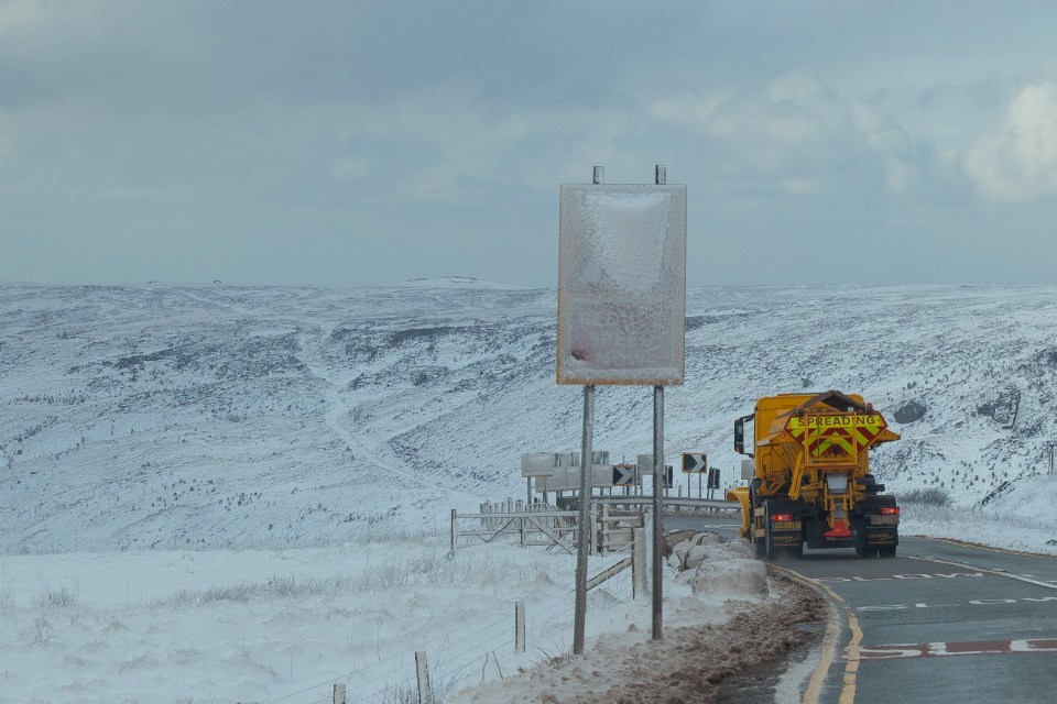 A gritter makes its way along Holmfirth Road near Dove stone reservoir