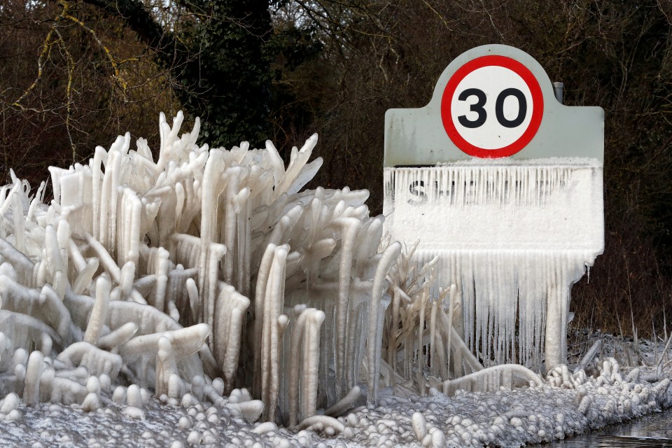 A frozen road sign and hedgerow are covered in icicles in Shenley, Hertfordshire