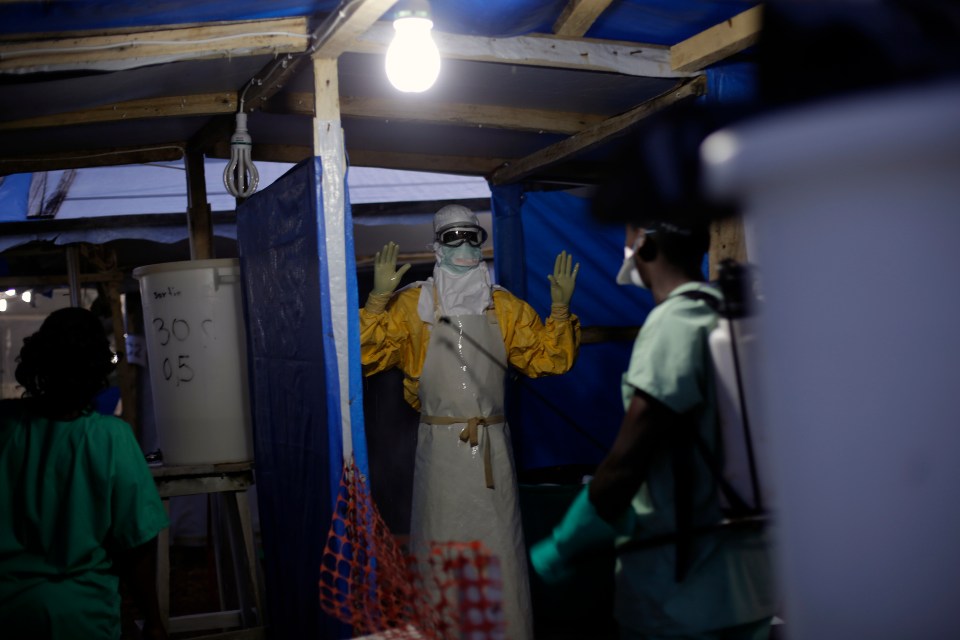 An MSF heath worker is sprayed as he leaves the contaminated zone at the Ebola treatment centre in Gueckedou, Guinea, in 2014