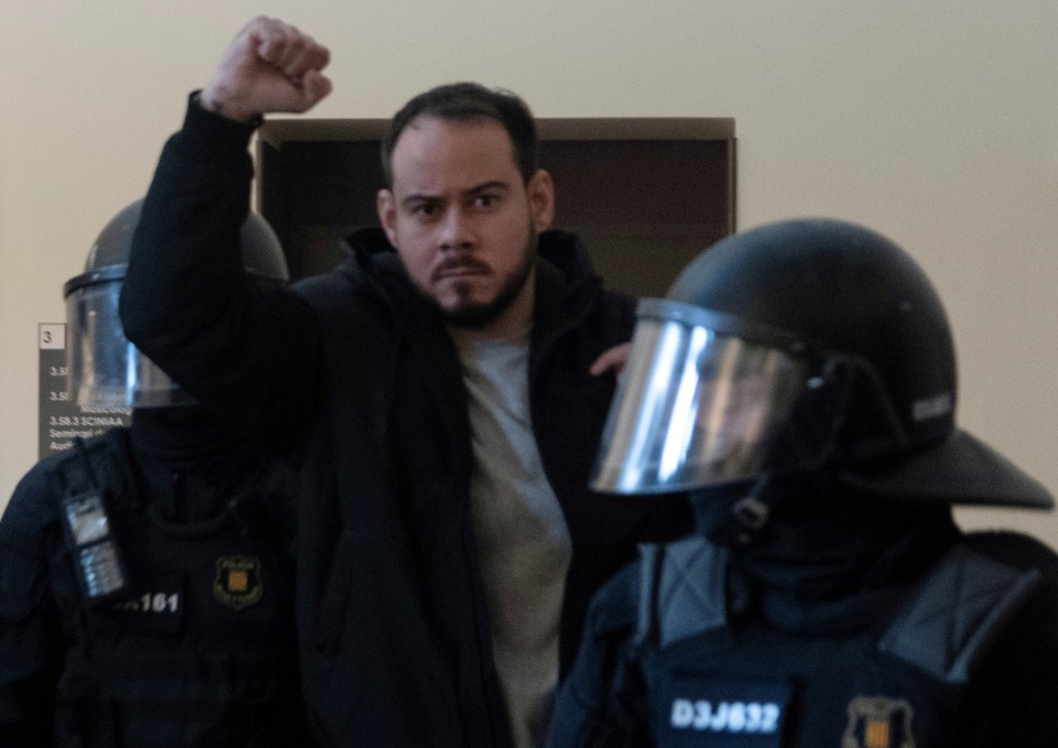 Catalan rapper Pablo Hasel raises his fist as he is led away by cops yesterday