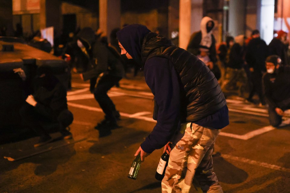 Masked rioters in hoodies were seen throwing bottles