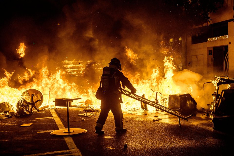 Firefighters tackle the burning barricades in Barcelona last night