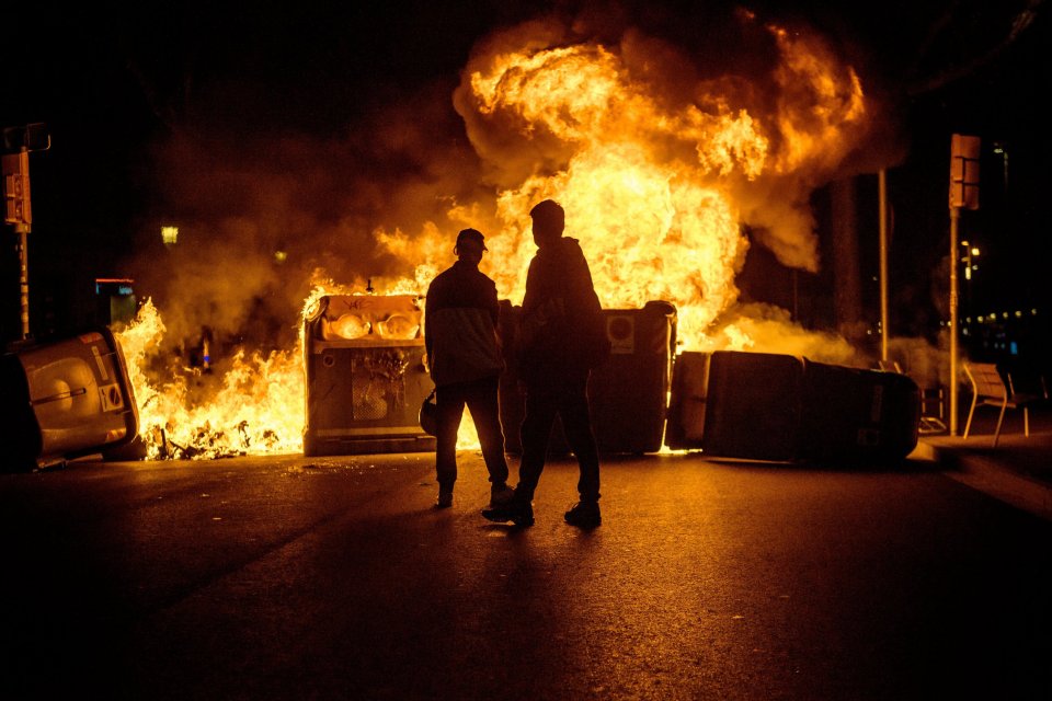 Demonstrators build barricades in the street and set them on fire