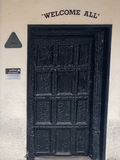 The door is covered in layers of black paint