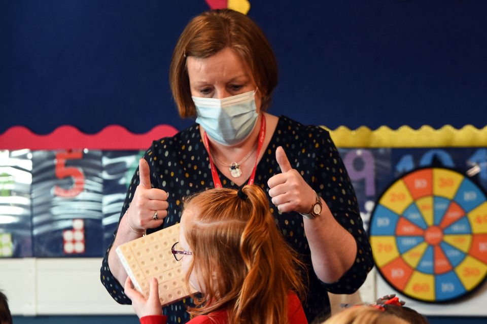 A teacher leads pupils in an activity as young Scots returned to class