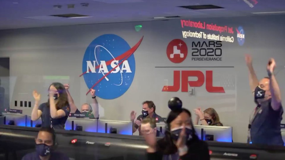 Nasa staff celebrating the safe landing of the $2.4billion robot