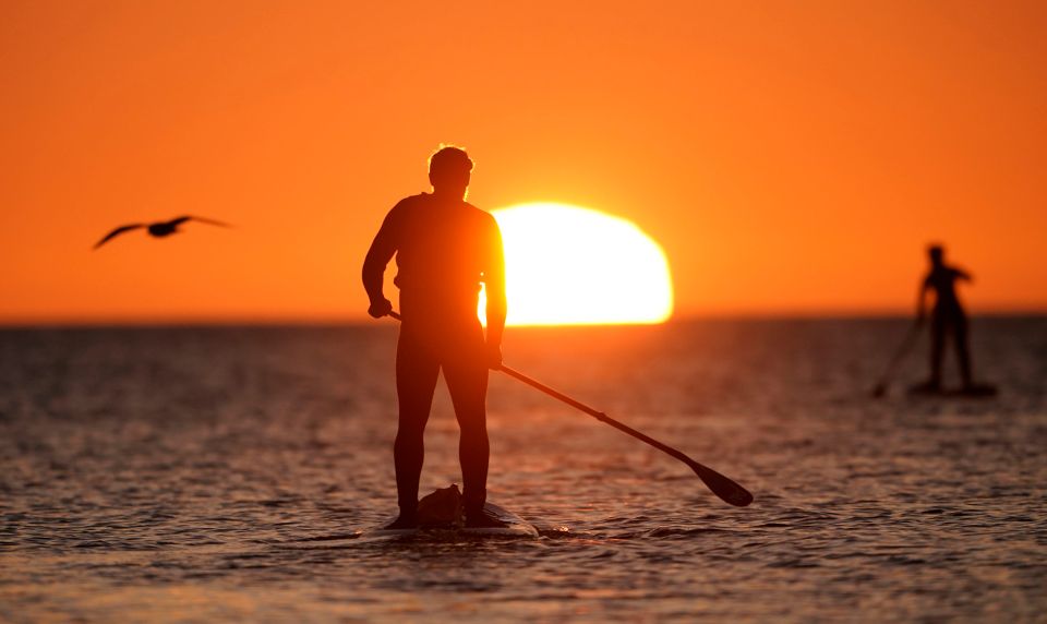 Paddleboarders at sunrise in Cullercoats Bay, North Tyneside, on the North East coast of England this morning