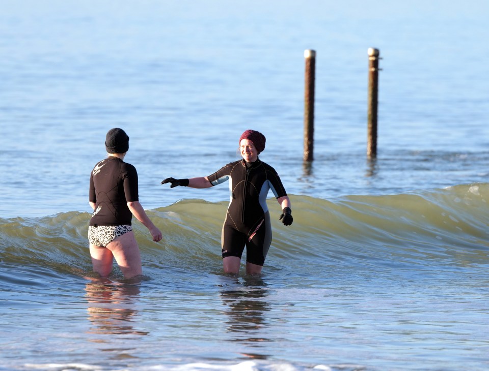 People out enjoying the sunshine at a beach in Poole in Dorset this morning