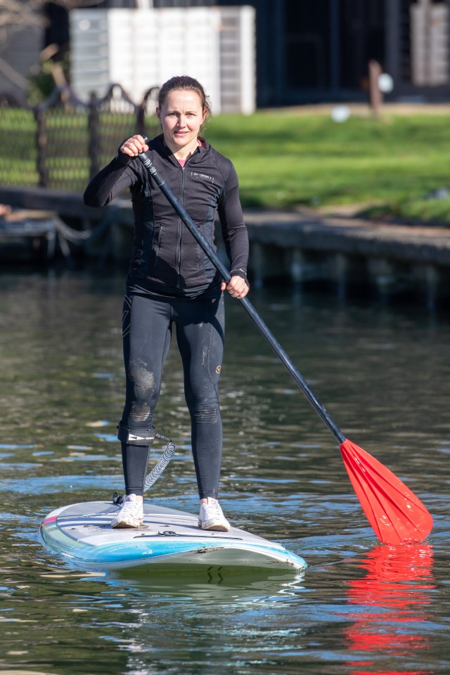 A woman paddle boards down the River Cam in Cambridge yesterday