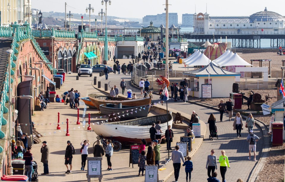 Walkers get the most of their daily exercise by walking along the beach in Brighton